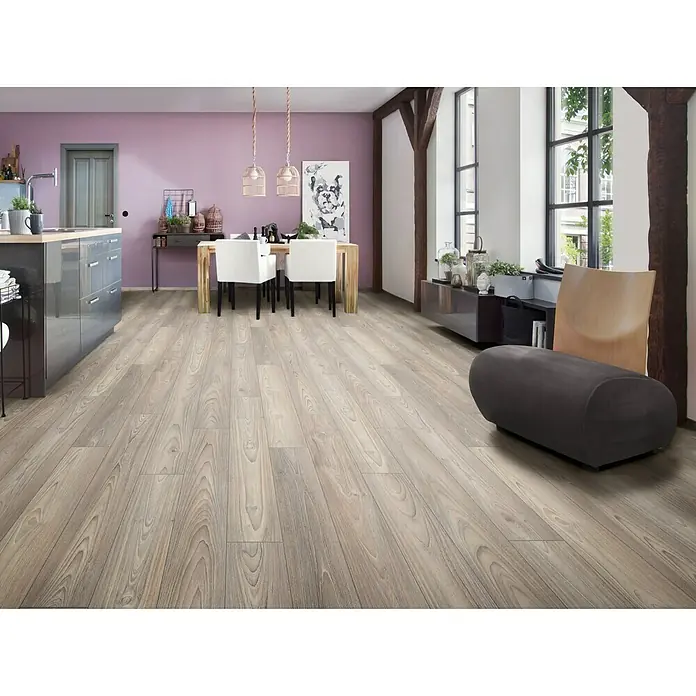 LOGOCLIC Ambienta Laminatmuster Eiche Alba - 296 x 195 x 1 mm, Landhausdiele - Innenaufnahme mit grauem Laminatboden, der in einem Winkel verlegt ist und eine moderne Küchen-, Ess- und Sitzecke verbindet.