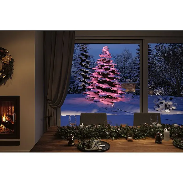 Paulmann Plug & Shine LED-Lichterkette Yuna - Außen, RGB, Länge: 7,4 m - Gemütliches Esszimmer mit Weihnachtsdeko, Blick auf einen verschneiten Garten mit rosafarben beleuchtetem Weihnachtsbaum.