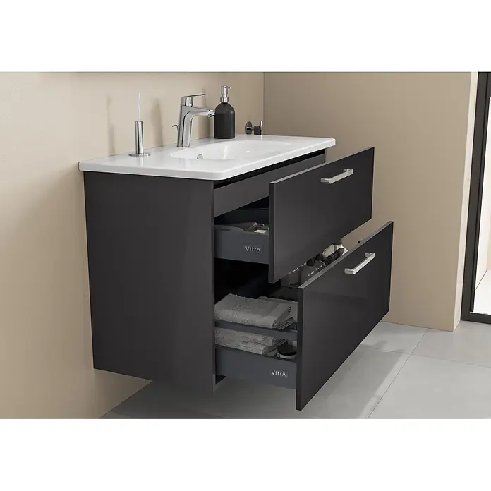 VitrA Badmöbel-Set Root Flat - B x T x H: 100 x 45 x 65 cm, Anthrazit, Hochglänzend - Wandhängender dunkelgrauer Waschtisch mit weißem Waschbecken, Chromarmatur und zwei offenen Schubladen, die Handtücher und Pflegeprodukte zeigen.