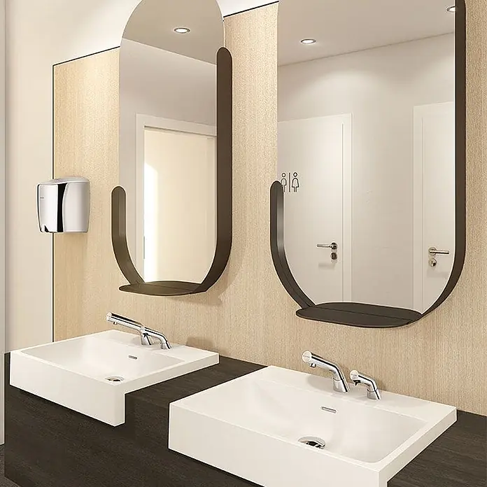 Delabie Waschbecken Delabie -  - Moderner Waschraum mit weißen Rechteckbecken, dunkel gerahmten ovalen Spiegeln mit Ablage und einem verchromten Händetrockner.