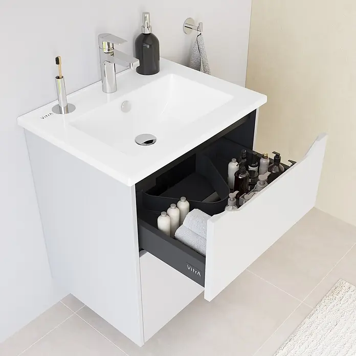 VitrA Integra Square Badmöbel-Set - Gesamtbreite Badmöbel: 60 cm, Hellgrau, Matt - Weißer Badschrank mit Waschbecken und offener Schublade. Dunkelgrauer Innenraum mit Toilettenartikeln und Handtuch. Chromarmatur, Seifenspender und Zahnbürste.