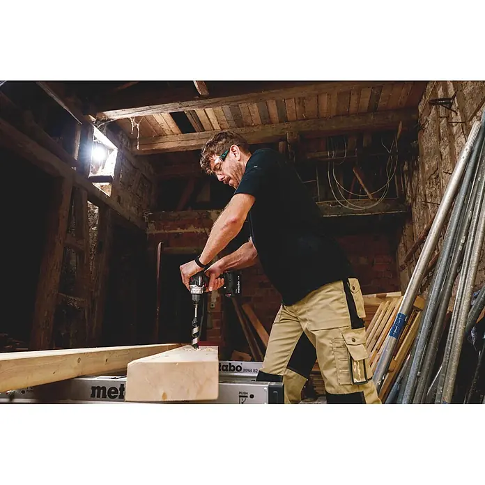 Metabo CAS 18V Akku-Bohrschrauber BS 18 Black Edition - 18 V, 1 Akku, 4 Ah, 60 Nm - Metabo Akku-Bohrmaschine in Schwarz-Rot, die ein Mann verwendet, um in einen Holzbalken zu bohren.