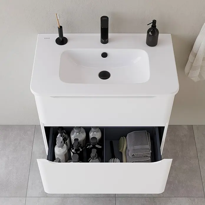 VitrA Integra Round Badmöbel-Set - Gesamtbreite Badmöbel: 80 cm, Weiß, Matt - Weißer Waschtisch mit integriertem Waschbecken, schwarzer Armatur und geöffneter Schublade mit Toilettenartikeln und Handtüchern.