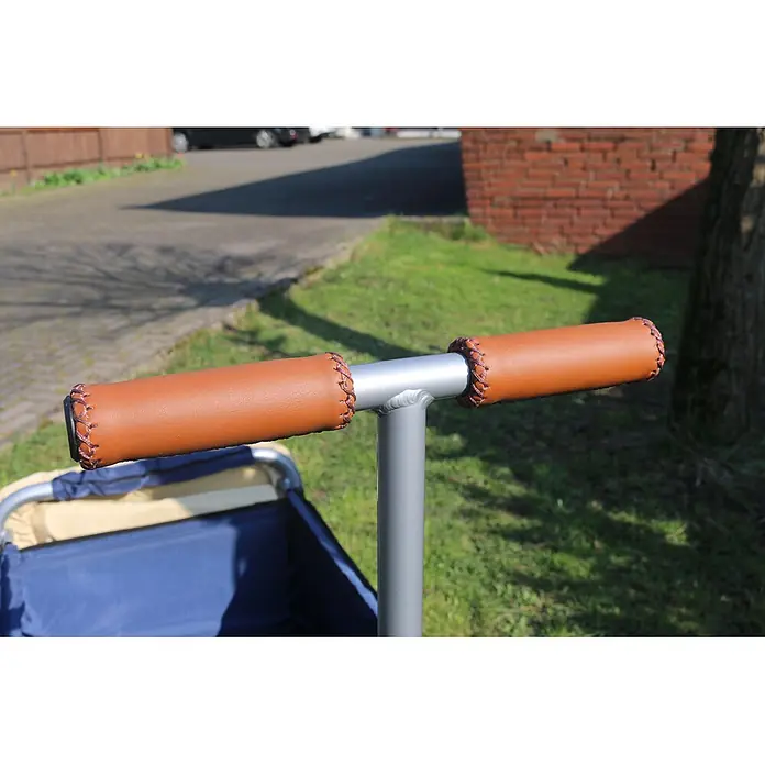 Beachtrekker Bollerwagen faltbarer Bollerwagen Life mit integrierter Feststellbremse und Sonnenverde - Kunststoff - Braune Leder-Lenkergriffe mit Zierstich auf einem silbernen Metallgriff eines Wagens.