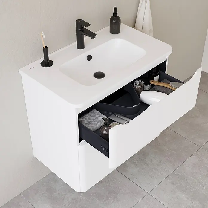 VitrA Integra Round Badmöbel-Set - Gesamtbreite Badmöbel: 80 cm, Weiß, Matt - Weißer Badunterschrank mit integriertem Waschbecken, schwarzer Armatur und geöffneter Schublade mit Badutensilien.