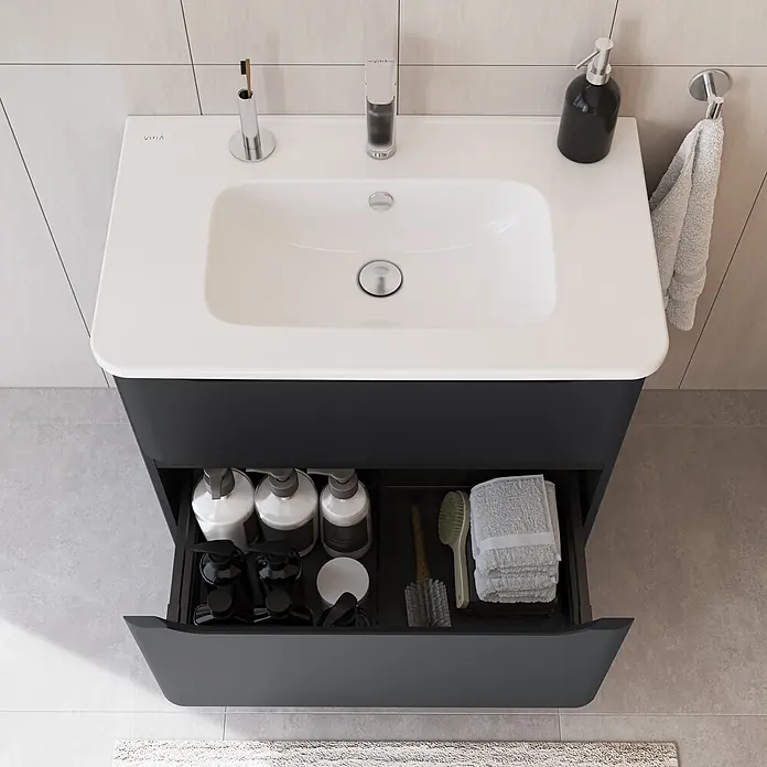 VitrA Integra Round Badmöbel-Set - Gesamtbreite Badmöbel: 80 cm, Graphit, Matt - Anthrazitfarbener Badschrank mit weißem Waschbecken, Chromarmatur und geöffneter Schublade voller Pflegeprodukte. Ein Handtuch hängt rechts.
