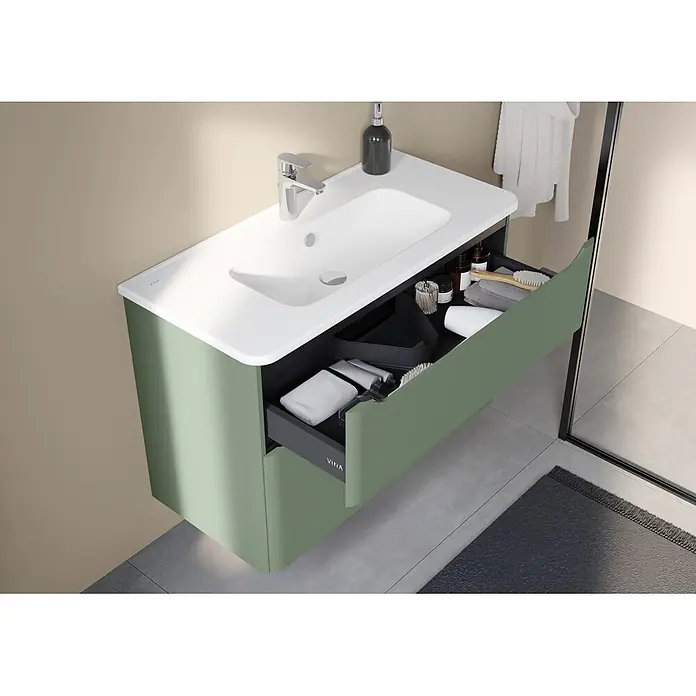 VitrA Integra Round Badmöbel-Set - Gesamtbreite Badmöbel: 100 cm, Moosgrün, Matt - Grüne wandhängende Badmöbel mit integriertem weißen Waschbecken, Chromarmatur und geöffneter Schublade mit Toilettenartikeln.