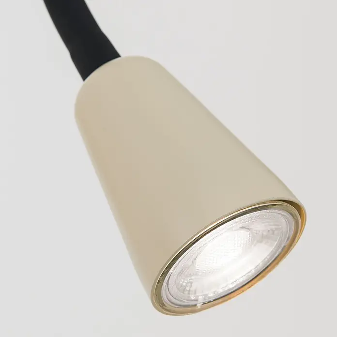 Orion Leuchten Wandleuchte - L x B x H: 20 x 20 x 55 cm, GU10 - Nahaufnahme eines beigen Lampenkopfs mit leuchtender LED-Lichtquelle, goldfarbenem Ring und schwarzem Flexhals.
