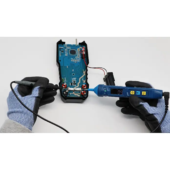 Pancontrol Spannungsprüfer - Messkategorie: CAT III 600 V - Blau-schwarzes Stift-Multimeter im Einsatz, von einer behandschuhten Hand gehalten, prüft eine Platinenkomponente.