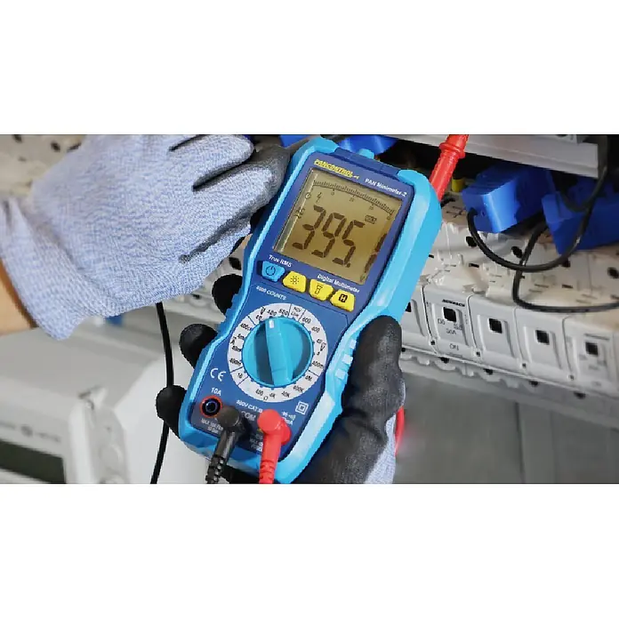 Pancontrol Kontaktloser Spannungsprüfer Digital-Multimeter PAN Minimeter-2 - Messbereich Wechselspannung: 0,1 V - 600 V, Messbereich Gleichstrom: 0,1 µA - 10 A, CAT III 600 V - Blau-schwarzes Digitalmultimeter, von behandschuhter Hand gehalten, Anzeige '395', an elektrische Komponenten angeschlossen.