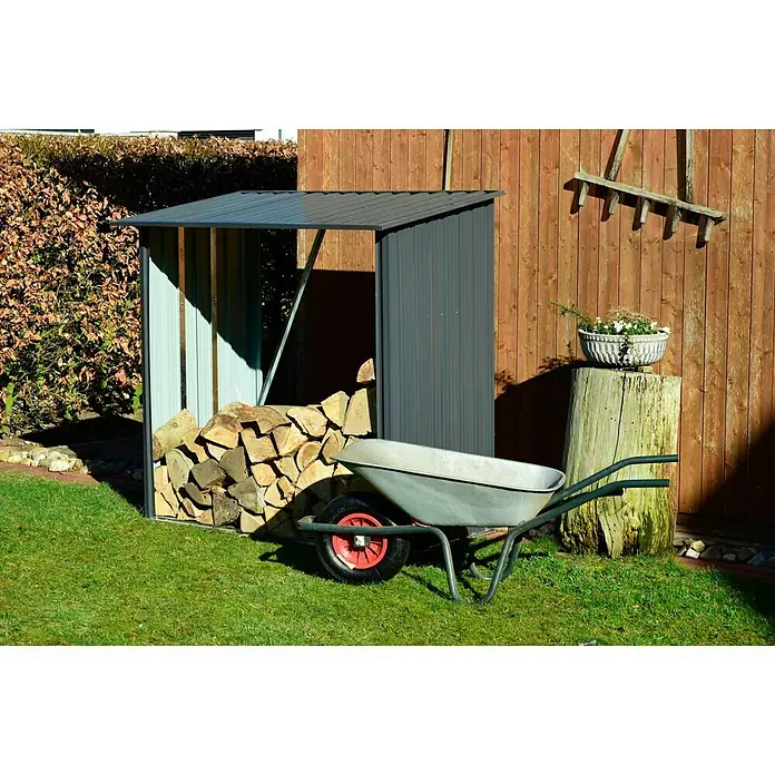 Dobar Kaminholzregal Madera - 163 x 83 x 154 cm, Metall, Metallic - Aufnahme eines Brennholzschuppens aus Metall, gefüllt mit Holzscheiten, mit einer Schubkarre davor, in einem Garten.