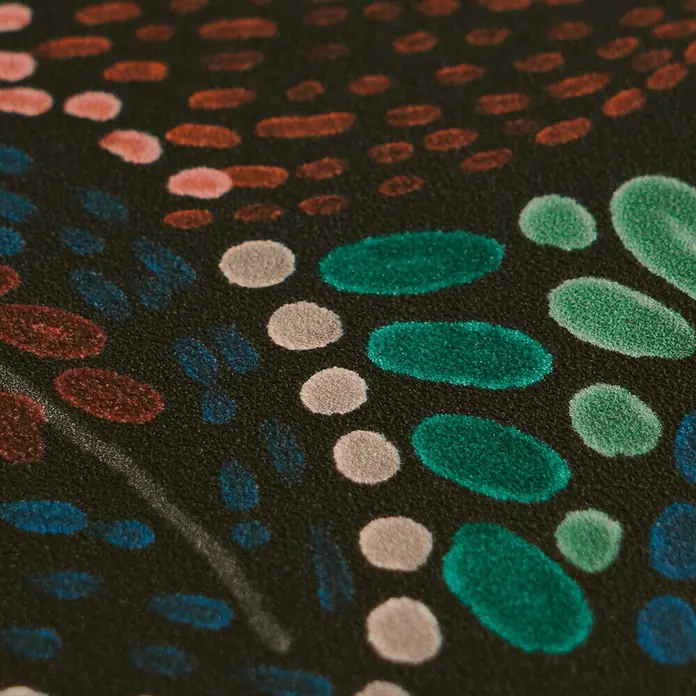 A.S. Création Cuba 2 Vliestapete Ethno - Grün-Braun, Floral, 10,05 x 0,53 m - Nahaufnahme eines dunklen Textils mit einem Muster aus strukturierten, farbigen Punkten in Rot, Blau, Grün und Weiß.