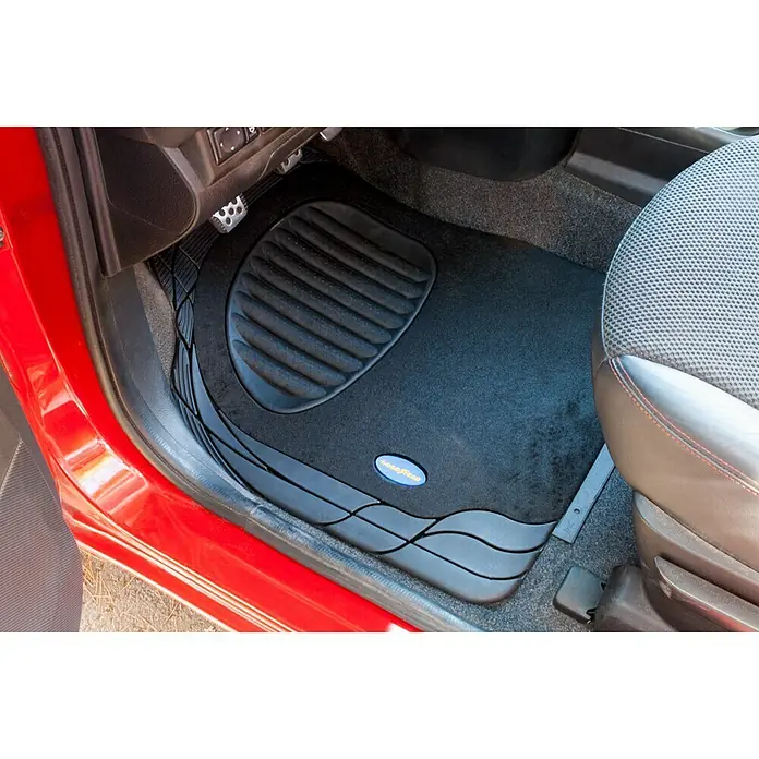 Goodyear Juego de alfombrillas para coche - Negro, 4 pzs. - Alfombrilla negra Goodyear para coche, colocada en la parte delantera de un coche rojo, diseñada para proteger el suelo y atrapar la suciedad.