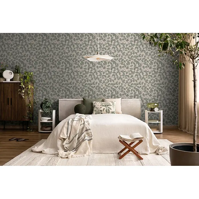 A.S. Création Nordic Feeling Vliestapete Blätter III - Grau-Grün, Floral, 10,05 x 0,53 m - Tapete mit grünem Blättermuster an den Wänden eines gemütlichen Schlafzimmers.