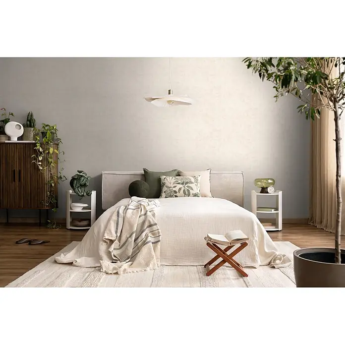 A.S. Création Nordic Feeling Vliestapete Uni - Creme-Grau, Uni, 10,05 x 0,53 m - Hellbeige, texturierte Tapete an den Wänden eines gemütlichen Schlafzimmers.