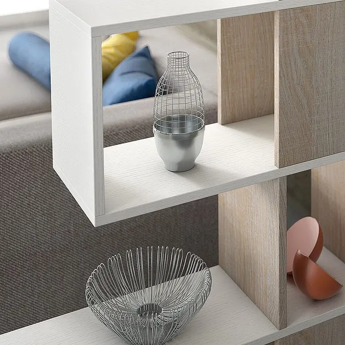 Kiamami Valentina Holzregal - Aufstellen, Weiß, Holzoptik - Modulares Regal in Weiß und heller Holzoptik mit offenen Fächern, das Dekoartikel neben einem Sofa präsentiert.