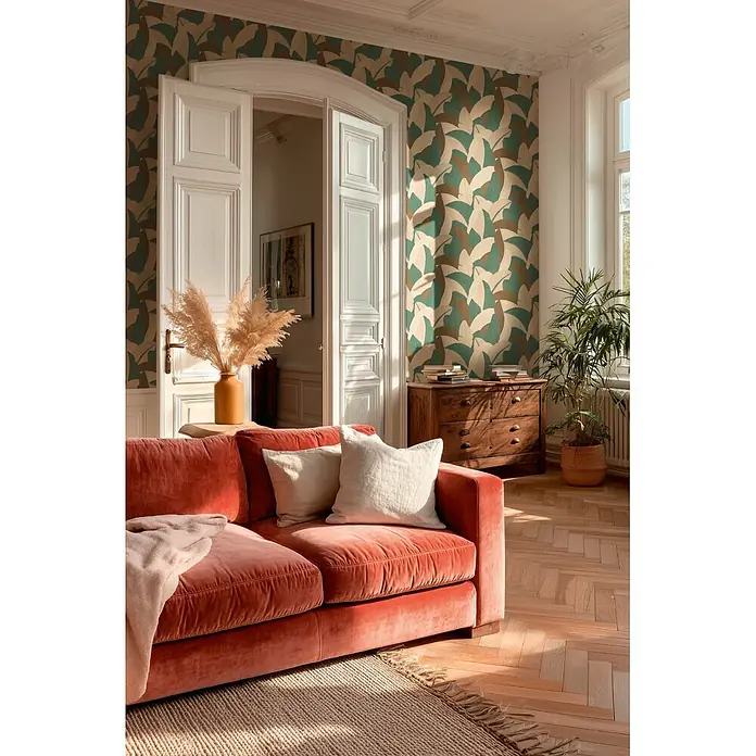 A.S. Création Metropolitan Stories Vibes & Styles Vliestapete Palme - Beige-Braun, Floral, 10,05 x 0,53 m - Rotes Samtsofa mit weißen Kissen in einem sonnigen Wohnzimmer.