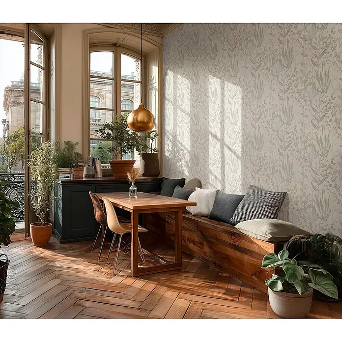 A.S. Création Metropolitan Stories Vibes & Styles Vliestapete Gräser - Creme-Grau, Floral, 10,05 x 0,53 m - Helle botanische Tapete mit grünen und blauen Motiven schmückt eine Wand in einem sonnigen Essbereich mit Holzbank und Tisch.