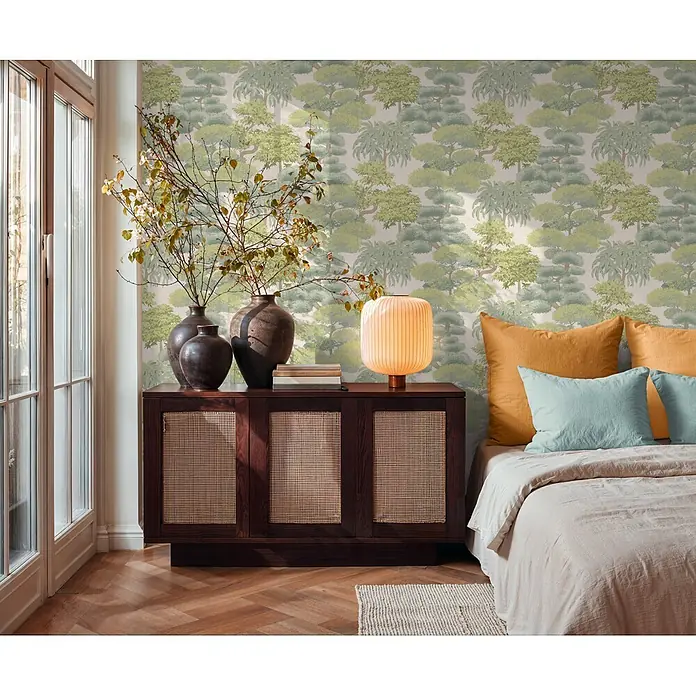 A.S. Création Cuba 2 Vliestapete Natur - Hellgrün-Creme, Floral, 10,05 x 0,53 m - Schlafzimmerwand mit grüner, stilisierter Baumtapete hinter Bett und Holzschrank.