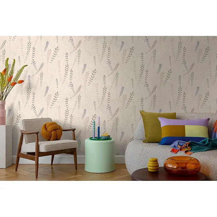 A.S. Création Nordic Feeling Vliestapete Skandi - Beige-Blau, Floral, 10,05 x 0,53 m - Dezente Tapete mit Blättermuster in Erdtönen auf hellem Beigegrund, schmückt eine Wohnzimmerwand hinter Sofa und Sessel.