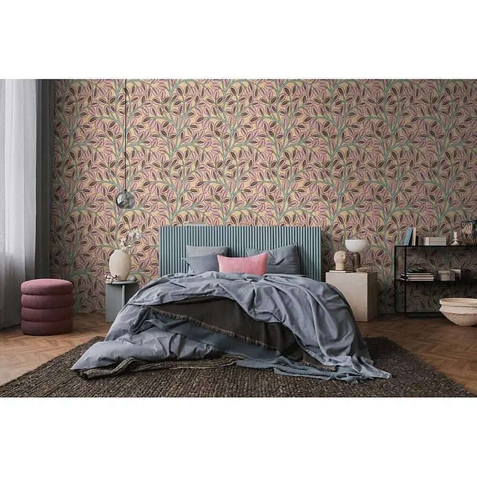 A.S. Création Nordic Feeling Vliestapete Blätter - Gelb-Braun, Uni, 10,05 x 0,53 m - Rosa und blaugrüne Blätter-Tapete an einer Schlafzimmerwand hinter einem blauen Kopfteil.