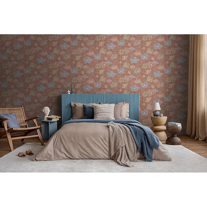 A.S. Création Nordic Feeling Vliestapete Floral - Braun-Rot, Floral, 10,05 x 0,53 m - Geblümte Tapete in Braun mit blauen und grünen Blüten schmückt eine Schlafzimmerwand über einem blauen Kopfteil.