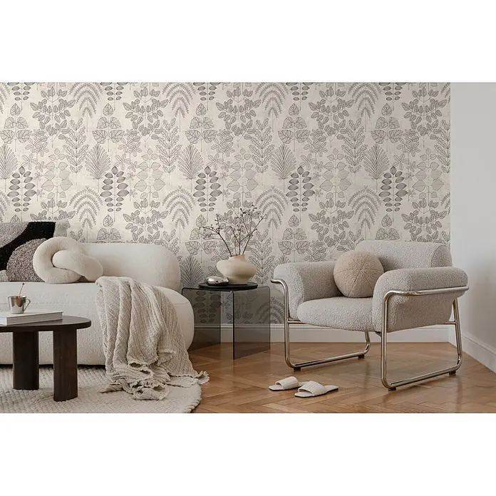A.S. Création Nordic Feeling Vliestapete Blätter II - Grau, Floral, 10,05 x 0,53 m - Tapete mit wiederholendem stilisiertem Pflanzenmuster aus Blättern und Ästen in dunklem Umriss auf hellem strukturiertem Hintergrund an einer Wohnzimmerwand.