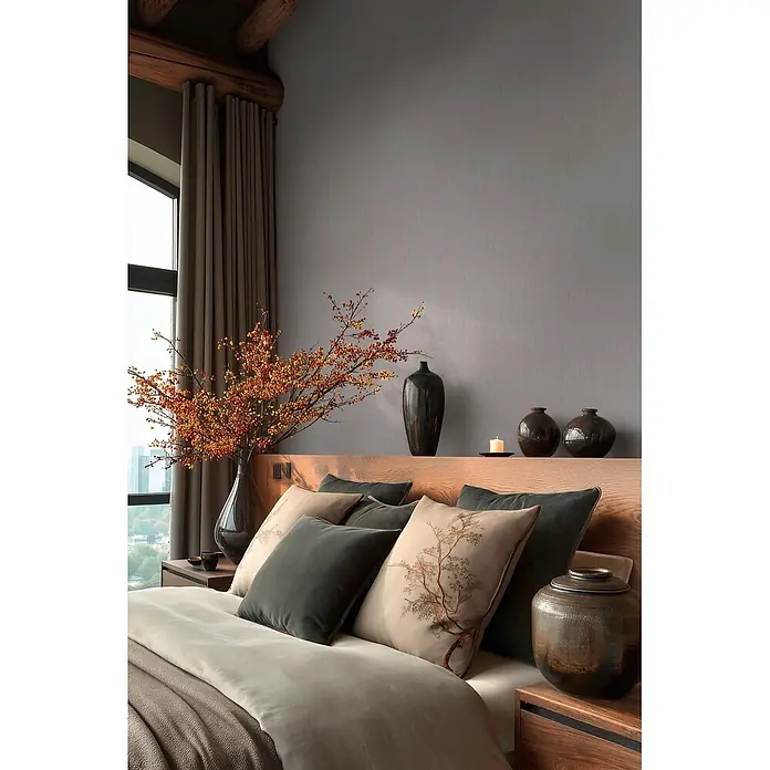 A.S. Création Metropolitan Stories Vibes & Styles Vliestapete Uni III - Grau, Uni, 10,05 x 0,53 m - Schlafzimmer mit Holzkopfteil, weicher grauer und beiger Bettwäsche, künstlerischen Kissen und naturinspirierten Zweigen und Vasen.