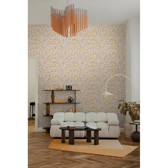 A.S. Création Nordic Feeling Vliestapete Blätter III - Gelb-Blau, Floral, 10,05 x 0,53 m - Gelbe Tapete mit weißem Blattmuster, kombiniert mit einem orange-weißen zylindrischen Kronleuchter in einem Wohnzimmer.