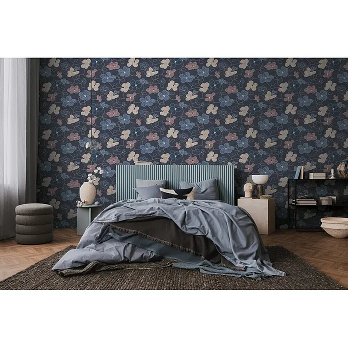 A.S. Création Nordic Feeling Vliestapete Floral - Blau-Grau, Floral, 10,05 x 0,53 m - Blumenmuster-Tapete mit blauen, rosafarbenen und beigefarbenen Blüten auf dunkelblauem Hintergrund in einem modernen Schlafzimmer.