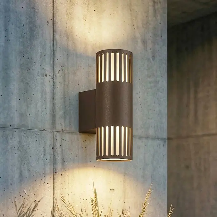 Lindby Wandleuchte aussen in braun, weiß, Aussenlampe Wand -  - Dunkle Bronze-Außenwandleuchte, wirft warmes Licht nach oben, unten und durch vertikale Schlitze.