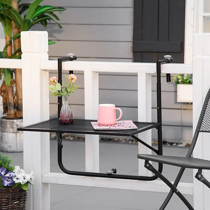 Outsunny Balkon-Hängetisch - Schwarz - Schwarzer Balkontisch aus Metallgitter, mit Tasse und Blumen, neben passendem Stuhl an Geländer.