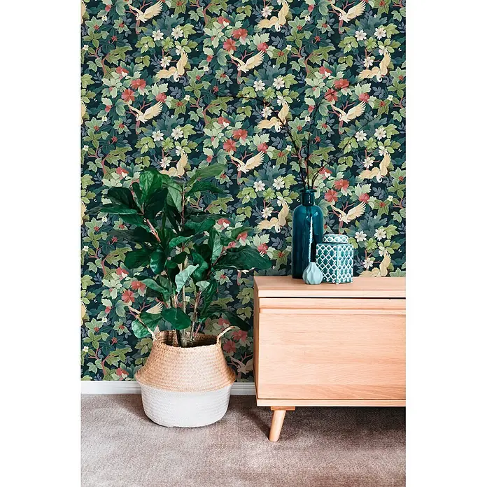A.S. Création Pintwalls 3 Vliestapete Botanik - Blau-Grün, Floral, 10,05 x 0,53 m - Dunkle botanische Tapete mit fliegenden Vögeln, grünen Blättern und roten/weißen Blüten an einer Wand.