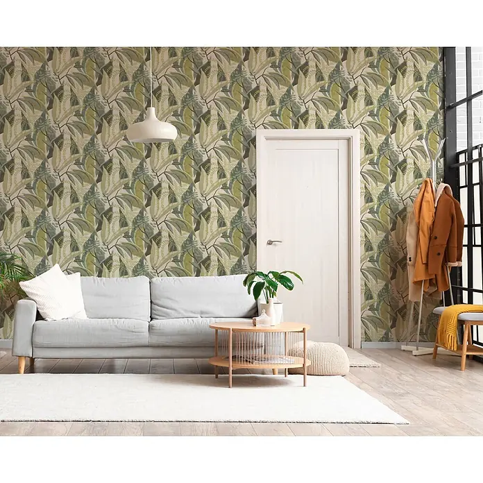 A.S. Création Pintwalls 3 Vliestapete Tropen - Grün-Creme, Floral, 10,05 x 0,53 m - Tapete mit grünem und hellgrünem Blattmuster an einer Wohnzimmerwand, die eine natürliche und lebendige Atmosphäre schafft.