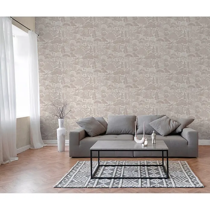 A.S. Création Pintwalls 3 Vliestapete Natur - Beige-Weiß, Floral, 10,05 x 0,53 m - Beigefarbene Tapete mit zartem Wald- und Baum-Muster an einer Wohnzimmerwand hinter einem grauen Sofa.