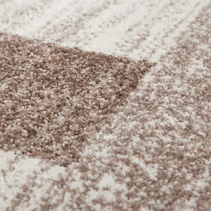 Kurzflorteppich Feeling 500 - Beige, 290 x 200 cm, 100 % Polypropylen (Flor) - Nahaufnahme eines Teppichs mit einem abstrakten, verschwommenen Muster in Beige- und Brauntönen, der eine weiche Textur und ein dezentes Design zeigt.