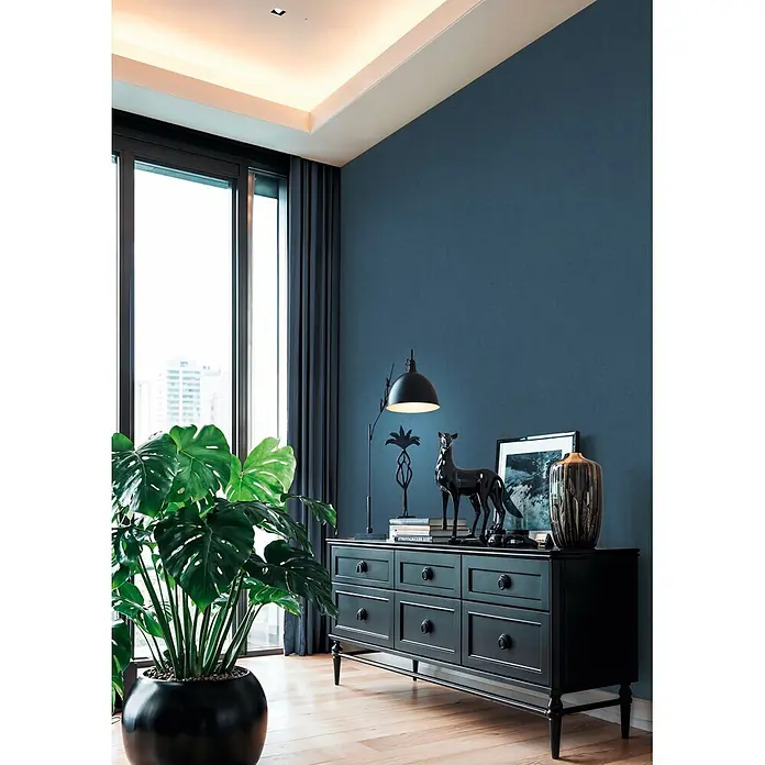 A.S. Création Cuba 2 Vliestapete Uni - Blau, Uni, 10,05 x 0,53 m - Schwarze Konsole mit mehreren Schubladen, dekoriert mit Lampe, Hirschstatue und Vasen, in einem modernen Raum.