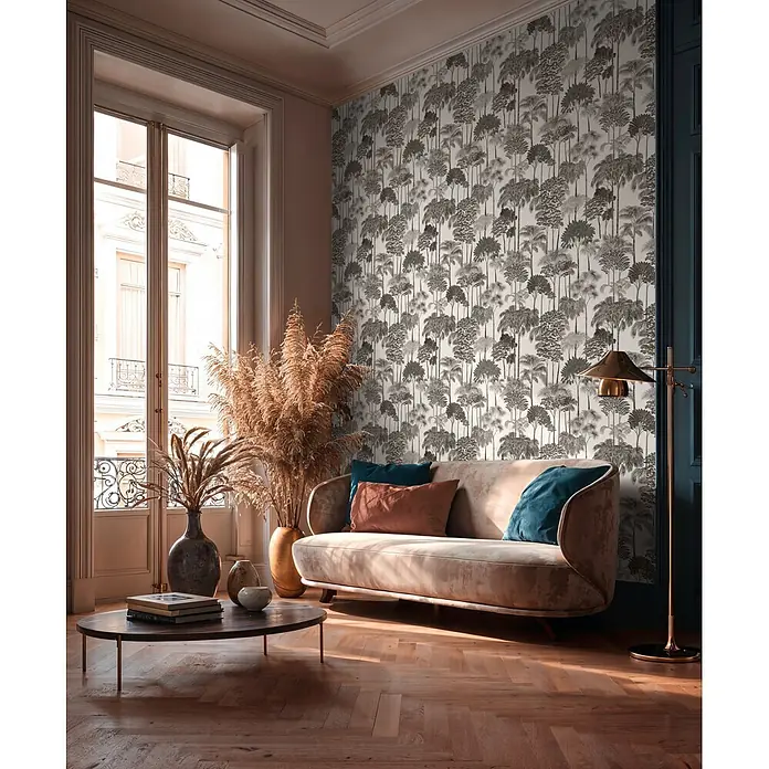 A.S. Création Cuba 2 Vliestapete Wald - Grau-Schwarz, Floral, 10,05 x 0,53 m - Wohnzimmer mit grauer Tropenbaum-Tapete, beigem Sofa und Couchtisch aus Holz.