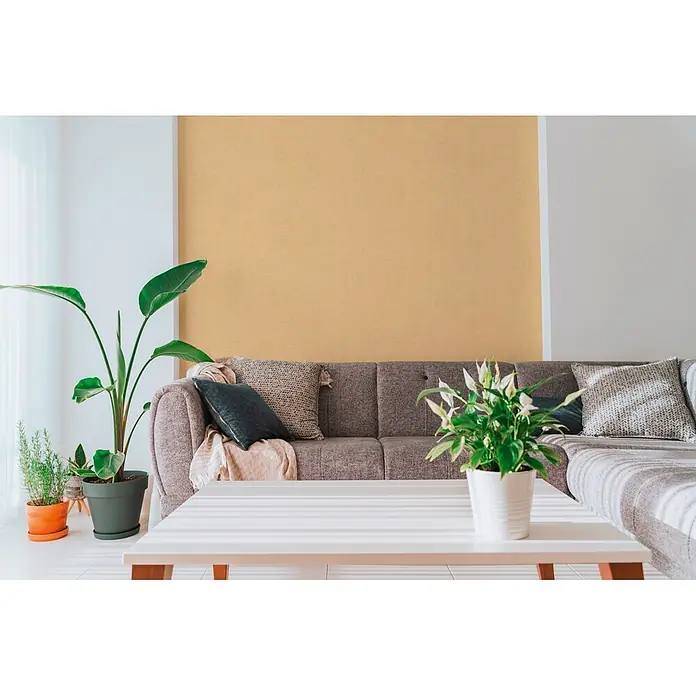 A.S. Création Cuba 2 Vliestapete Uni - Geld-Braun, Uni, 10,05 x 0,53 m - Strukturierte Ocker-Tapete an einer Wohnzimmerwand hinter einem Sofa.