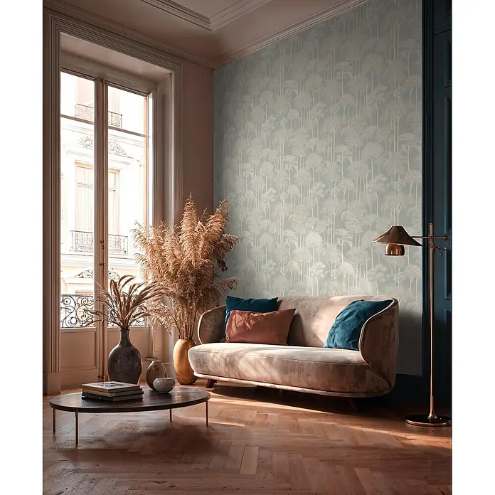 A.S. Création Cuba 2 Vliestapete Wald - Creme-Grün, Floral, 10,05 x 0,53 m - Elegantes Wohnzimmer mit hellem Samtsofa, petrolfarbenen und rostfarbenen Kissen, gemusterter Baumtapete und warmem Fischgrätparkett.