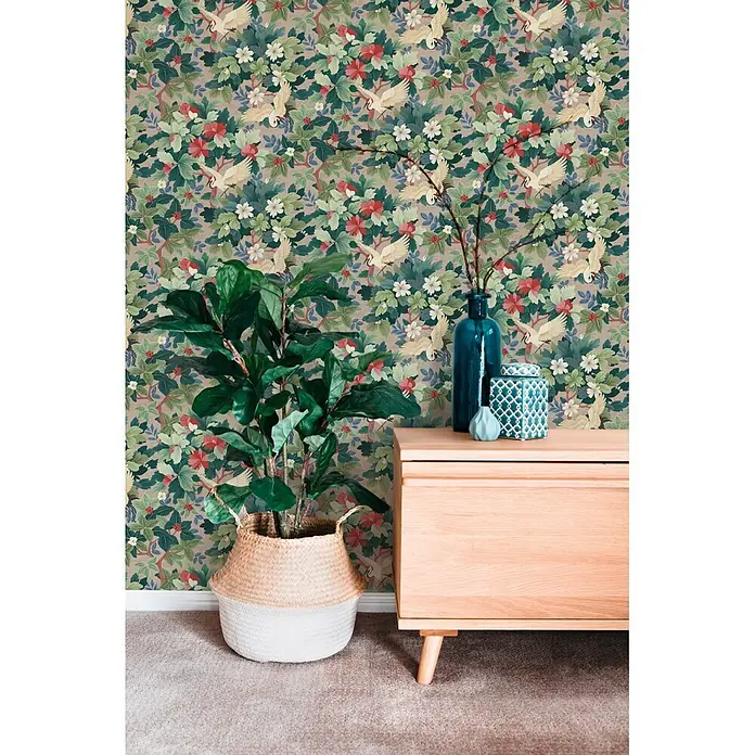 A.S. Création Pintwalls 3 Vliestapete Botanik - Beige-Grün, Floral, 10,05 x 0,53 m - Botanische Tapete: grüne Blätter, rot/weiße Blüten, weiße Kraniche auf hellbraunem Grund, hinter Pflanze und Konsole.