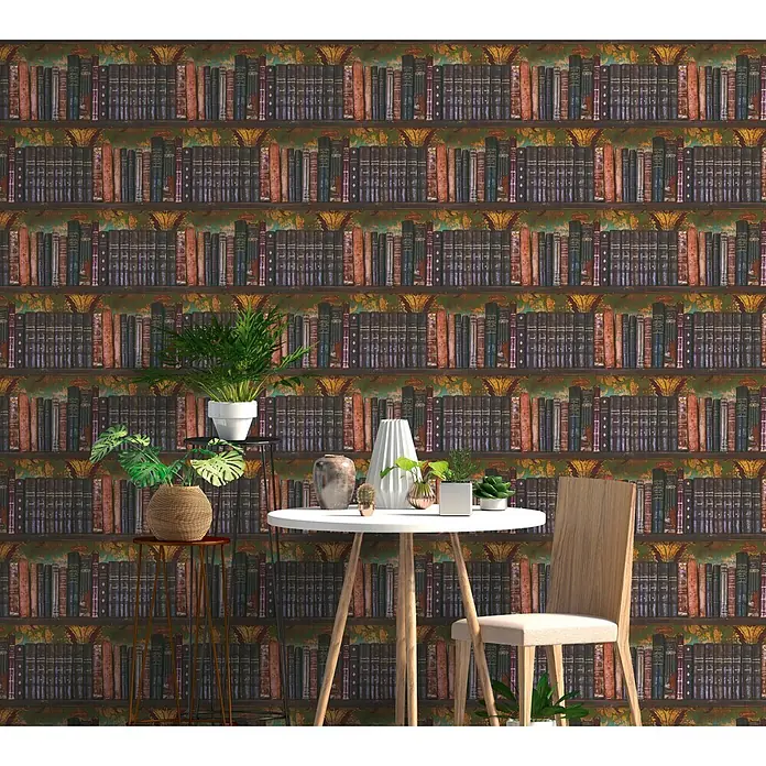 A.S. Création Pintwalls 3 Vliestapete Bücher - Grün-Braun, Sonstiges, 10,05 x 0,53 m - Ein kleiner Essbereich mit rundem weißen Tisch, Holzstuhl und Topfpflanzen vor einer Bücherregal-Tapete.