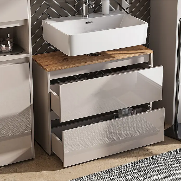 Vicco Badmöbel-Set Majest Cashmere 3 Teile - Cashmere, Matt - Hellgrauer Hochglanz-Badschrank mit weißem Waschbecken, Holzplatte und zwei halb geöffneten Schubladen.