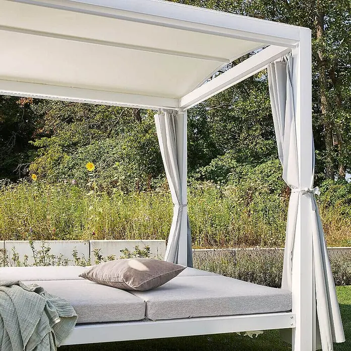 Home Deluxe Gartenliege LYON - B x T: 188 x 208 cm, Weiß, Grau, Polyester - Weißes Aluminium-Tagesbett für draußen mit hellgrauen Polstern, braunem Kissen und grüner Decke, weißem Verdeck und grauen Vorhängen.
