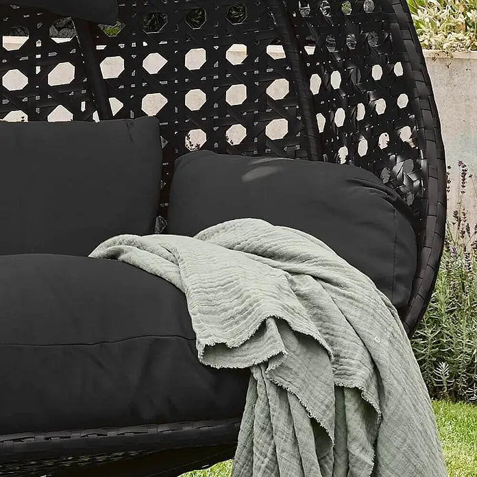 Home Deluxe Hängesessel TWIN - L x B x H: 74 x 145 x 126 cm, Schwarz - Schwarzer Hängesessel im Rattan-Stil mit schwarzen Kissen und hellgrüner Decke.