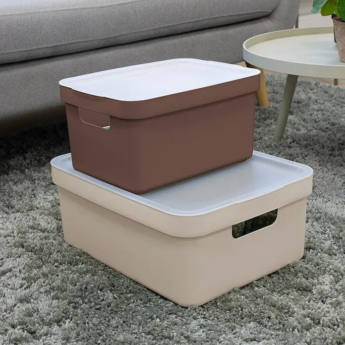 Sunware Sigma home Deckel - L x B x H: 36,1 x 25,4 x 0,8 cm, Passend für: Sigma home Aufbewahrungsbox 9l, 13l, 18l & 25l, Kunststoff, Transparent - Zwei gestapelte Kunststoff-Aufbewahrungsboxen mit Deckeln, beige und dunkelbraun, in einem Wohnzimmer.