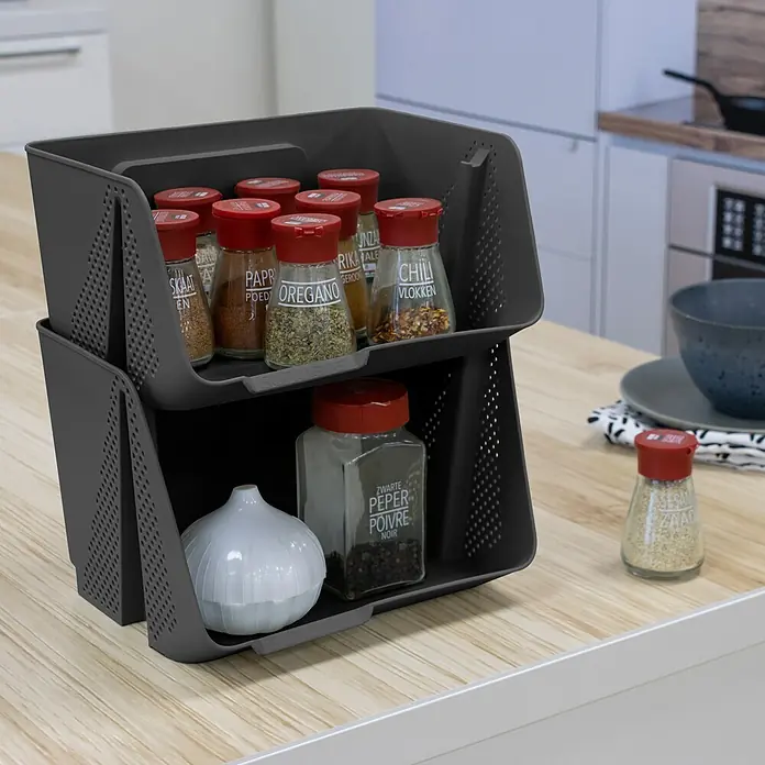 Sunware Sigma home Schreibtisch-Organizer Stackable - L x B x H: 20 x 25 x 13 cm, Anthrazit, Kunststoff - Dunkelgrauer zweistufiger, stapelbarer Gewürzständer aus Kunststoff auf einer Küchentheke, mit Gewürzgläsern und einem Knoblauchbehälter.