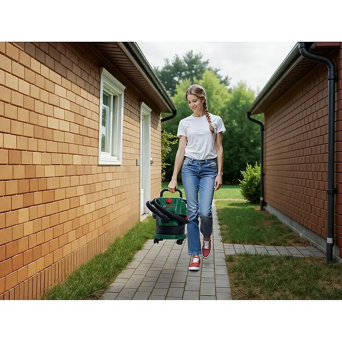 Bosch Elektro-Nass- & Trockensauger PAS 15-200 - 1.200 W, Behältervolumen: 15 l - Eine Person trägt einen tragbaren grün-schwarzen Bosch Nass-/Trockensauger, was seine Nutzung im Freien zeigt.