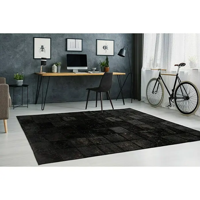 Kayoom Lederteppich Viola - Schwarz, 170 x 120 cm, 100 % Echtleder - Schwarzer Teppich mit rechteckigem Muster, der in einem modern eingerichteten Raum vor einem Schreibtisch liegt.