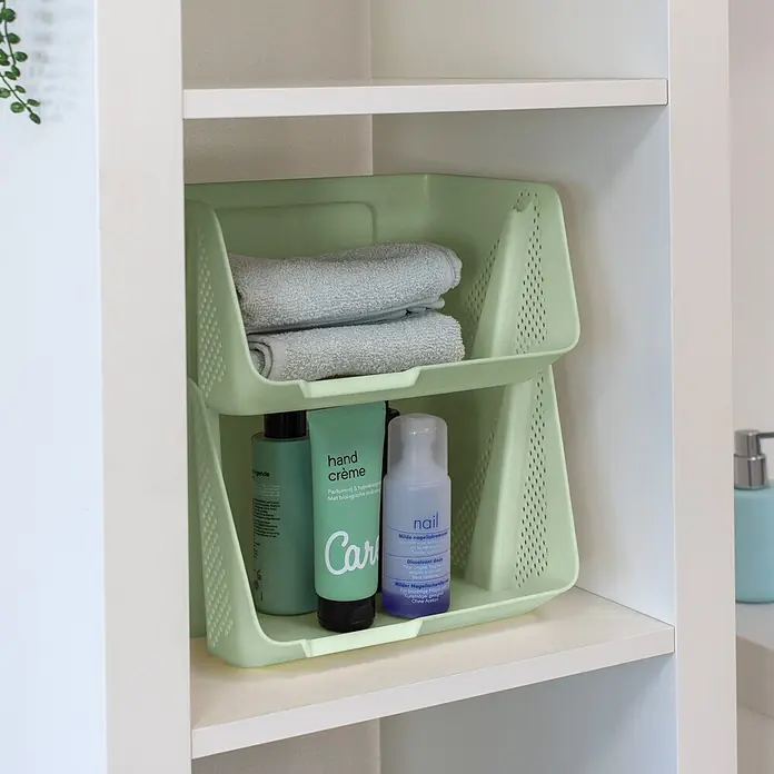 Sunware Sigma home Schreibtisch-Organizer Stackable - L x B x H: 20 x 25 x 17,5 cm, Grün, Kunststoff - Hellgrüner, perforierter, stapelbarer Kunststoffkorb im Regal, gefüllt mit Handtüchern und Pflegeprodukten.